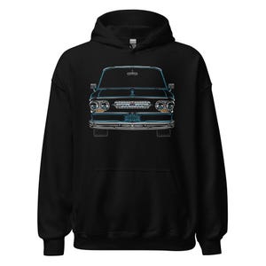 Könnte beinhalten: Schwarzer Kapuzenpullover mit einer detaillierten blauen Umrissillustration der Front eines klassischen Autos. Das Design hebt die Scheinwerfer, den Kühlergrill und das Nummernschild hervor. Die Autoillustration ist auf der Brust zentriert.