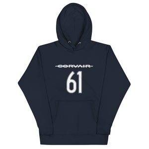 Könnte beinhalten: Ein marineblauer Kapuzenpullover mit weißem Text, der "CORVAIR 61" lautet.