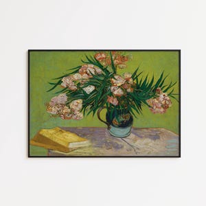 Puede incluir: Impresión enmarcada de una pintura de naturaleza muerta con un ramo de flores rosas y blancas en un jarrón azul. Un libro amarillo descansa sobre una mesa frente al jarrón, sobre un fondo verde.