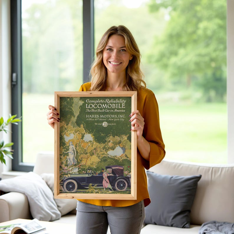 May include: A framed vintage advertisement for the Locomobile, a classic car. The advertisement features a green and beige background with an illustration of a car and figures. The text reads "Complete Reliability Locomobile The Best Built Car in America."