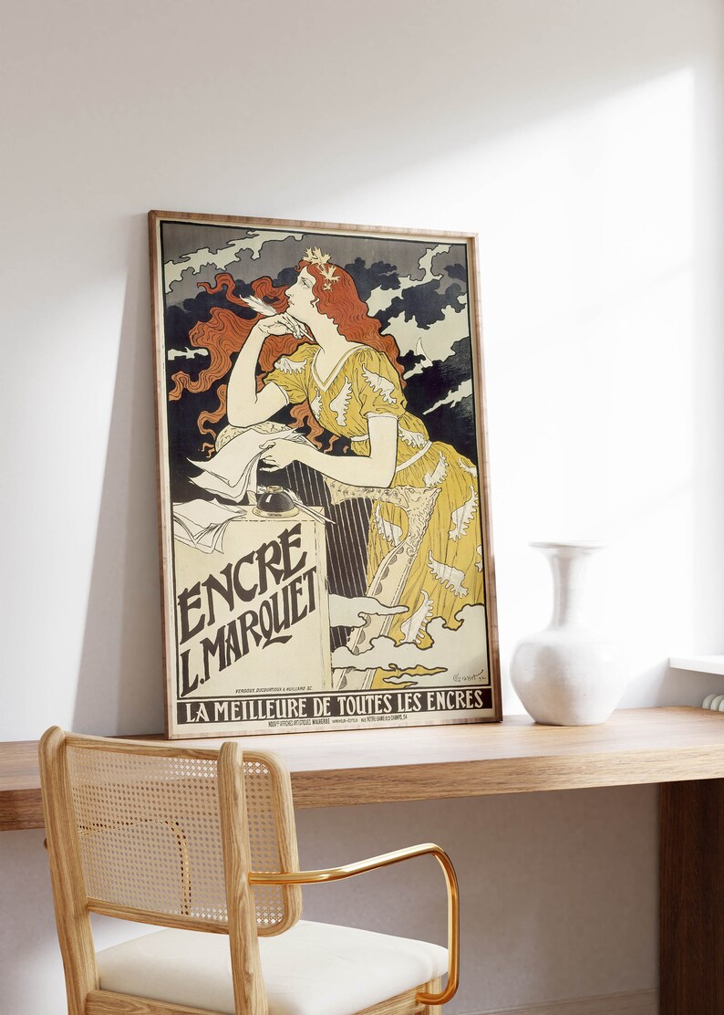 May include: A vintage poster advertising "Encre L'Marquet" ink. The poster features a woman with flowing red hair, wearing a yellow dress with white wings, against a backdrop of dark clouds. The text "LA MEILLEURE DE TOUTES LES ENCRES" is at the bottom of the poster.