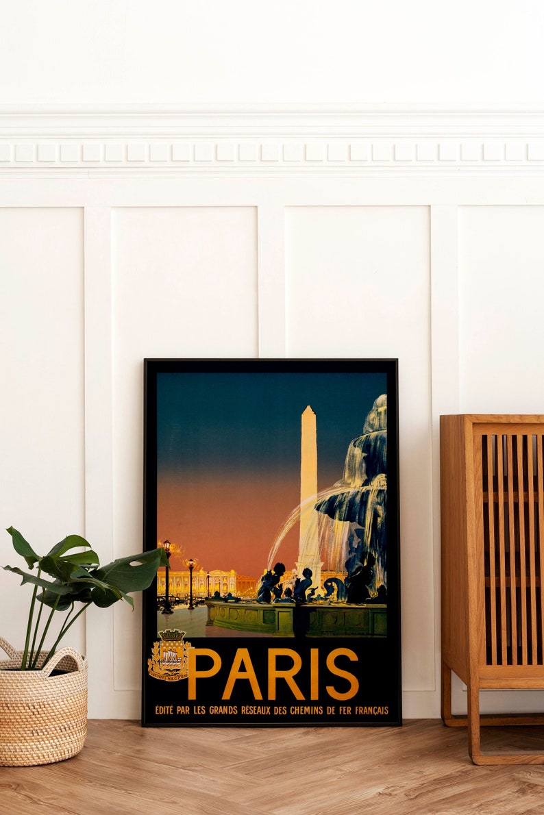 May include: A vintage travel poster advertising Paris, France. The poster features a black and white illustration of a fountain and a tall obelisk in front of a building. The sky is a gradient of orange, pink, and blue. The text on the poster reads "Paris" in gold letters and "Edite par les grands reseaux des chemins de fer francais".