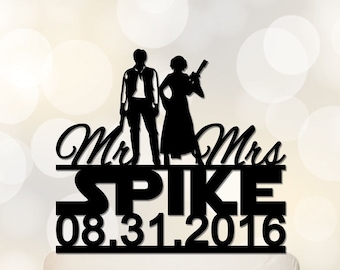 May include: Black silhouette of a couple dressed as Han Solo and Princess Leia from Star Wars. The couple is standing on a cake topper with the text "Mr. & Mrs. SPIKE 08.31.2016" below them.