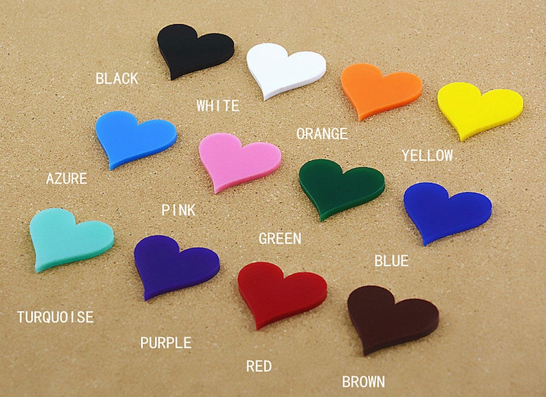 May include: A collection of 12 heart-shaped acrylic pieces in various colors, including black, white, orange, yellow, azure, pink, green, blue, turquoise, purple, red, and brown. Each heart is labeled with its corresponding color.
