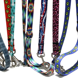 May include: Seven colorful dog leashes with different patterns, including paw prints, stars, and abstract designs. Each leash has a silver metal clip.