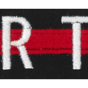 Peut inclure: Écusson brodé noir et rouge avec du texte blanc qui dit "YOUR TEXT".