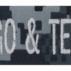 May include: A dark blue and grey camouflage fabric patch with a red medical cross and the text "LOGO & TEXT HERE" in white.