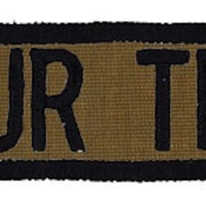May include: A black and brown rectangular patch with a black border and the text "YOUR TEXT" in black.