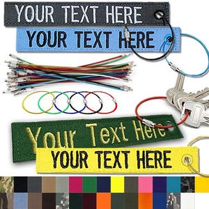 May include: Assortment of keychains and key tags in various colors. Key tags include black, blue, green, and yellow with the text "YOUR TEXT HERE". Keychains and key tags are shown with a variety of colored wires and key rings. A color chart is shown at the bottom.