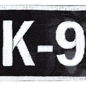 May include: White embroidered patch with black background and the text "K-9" in white.