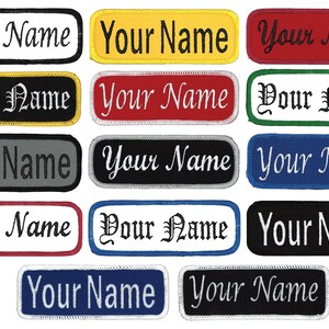May include: A collection of 15 iron-on patches with different colored borders and fonts. The patches are all rectangular and feature the text "Your Name" in white or black thread.