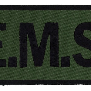 May include: A green rectangular patch with black embroidered text that reads "E.M.S."