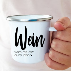 Puede incluir: Taza de esmalte blanco con una inscripci&oacute;n negra que dice "Wein w&auml;re mir jetzt auch lieber" con un peque&ntilde;o coraz&oacute;n negro.