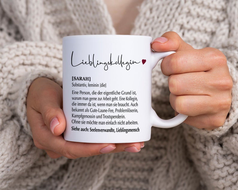May include: White ceramic mug with a black and red design. The mug features the text "Lieblingskollegin" and a definition of the word "Sarah" in German.