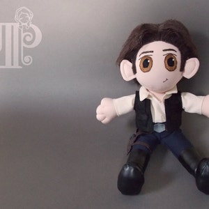 May include: A plush toy of a character wearing a brown vest, white shirt, and blue pants. The toy has brown hair, brown eyes, and a light brown face.