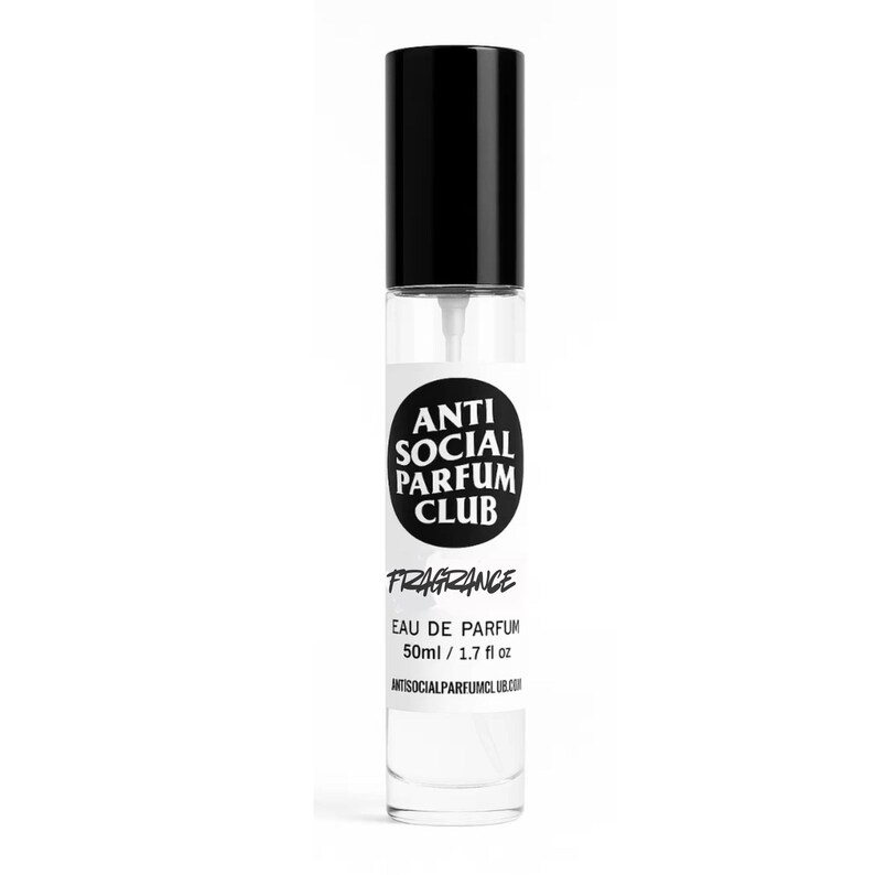May include: A clear glass fragrance bottle with a black cap. The bottle has a white label with the text "ANTI SOCIAL PARFUM CLUB" in a black circle. Below the circle is the word "FRAGRANCE" and the text "EAU DE PARFUM 50ml / 1.7 fl oz".