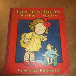 May include: A vintage children's book titled "Golden Hours Mother with Goose" with a red cover and a picture of a girl in a yellow dress with red polka dots and a red bow in her hair. The book is published by Sunshine Printery.