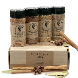 May include: A set of four spice blends in glass jars with brown labels. The labels feature a windmill logo and the text "High Plains Spice Company". The jars are arranged in a box with the text "Sweet & Spicy BBQ" and a list of the four blends: "Honey BBQ Blend", "Sweet Chili Maple", "Heat & Honey", and "Back Porch BBQ Blend".