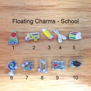 May include: Ten colorful school-themed charms for a charm bracelet. The charms include a stack of books, a pencil, a school bus, a globe, a paint palette, a music note, a heart with the words "I love school", and a graduation cap.