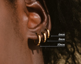 May include: Close-up of a person's ear with three gold hoop earrings of different sizes. The earrings are labeled 6mm, 8mm, and 10mm.