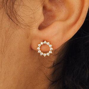 Our Helen Stud Earrings worn on our model's earlobe- featuring 10mm Sun-Shaped Open Circle Diamond Stud Earrings in 18K Gold and a push back closure.