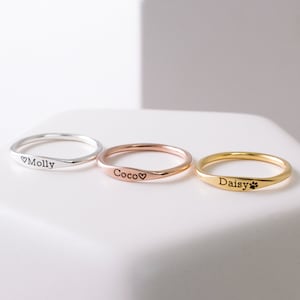 以下が含まれることがあります： 名前が刻まれた、3つのパーソナライズされたリング。リングはシルバー、ローズゴールド、ゴールド。名前は「モリー」、「ココ」、「デイジー」。