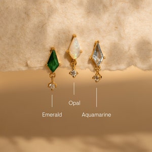 May include: Three gold earrings with different gemstones: emerald, opal, and aquamarine. Each earring features a small diamond dangle.