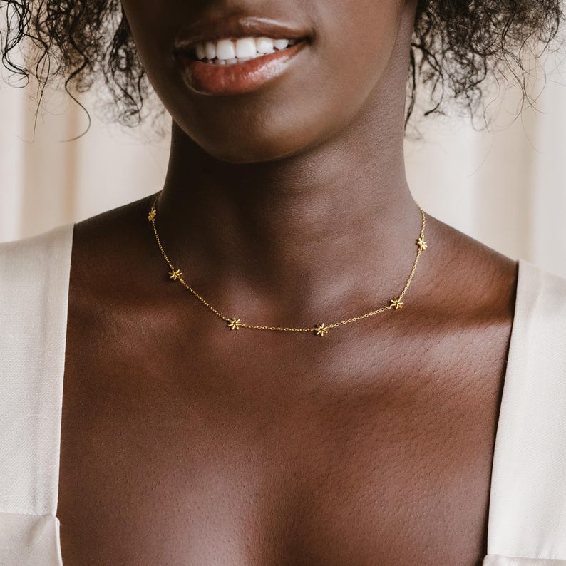 May include: A gold necklace with a delicate chain and small star-shaped charms.