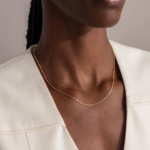 Model wearing the Dot Station Necklace in gold, featuring a dainty beaded chain design.