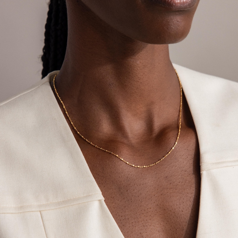 Model wearing the Dot Station Necklace in gold, featuring a dainty beaded chain design.