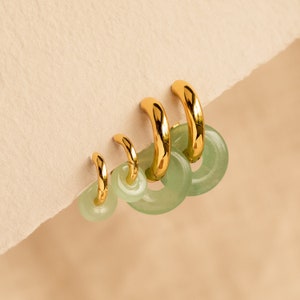 Peut inclure: Ensemble de quatre boucles d'oreilles cr&eacute;oles dor&eacute;es avec des accents de jade vert. Les cr&eacute;oles sont gradu&eacute;es en taille, la plus grande en haut et la plus petite en bas.
