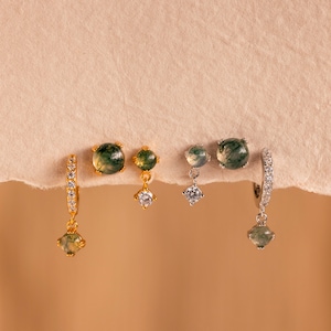 May include: Three pairs of earrings with green agate stones and clear cubic zirconia accents. The earrings are in gold and silver.