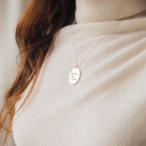 May include: A silver necklace with a round pendant that says "love Mom" in cursive handwriting.
