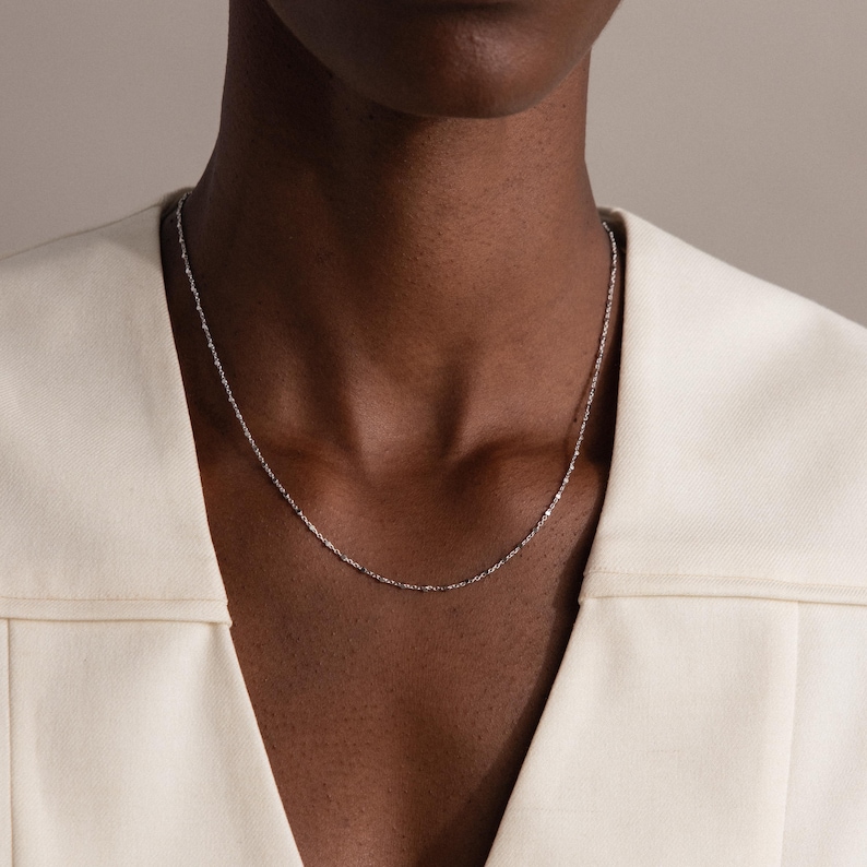 Model wearing the Dot Station Necklace in silver, featuring a dainty beaded chain design.