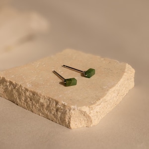 K&ouml;nnte beinhalten: Ein Paar silberne Ohrstecker mit kleinen, rechteckigen gr&uuml;nen Jade-Steinen.