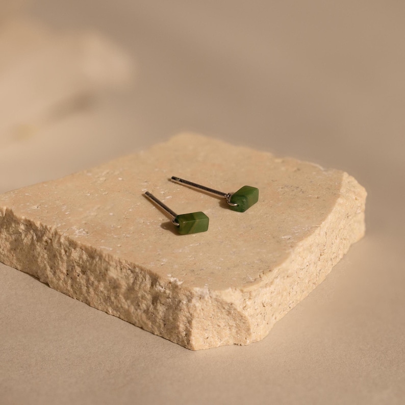 K&ouml;nnte beinhalten: Ein Paar silberne Ohrstecker mit kleinen, rechteckigen gr&uuml;nen Jade-Steinen.