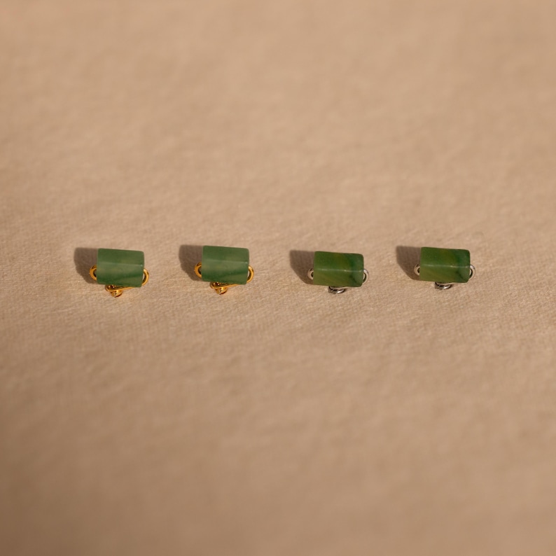 K&ouml;nnte beinhalten: Vier gr&uuml;ne Jade-Ohrringe mit goldenen und silbernen Verschl&uuml;ssen. Die Ohrringe sind rechteckig und haben eine hellgr&uuml;ne Farbe.