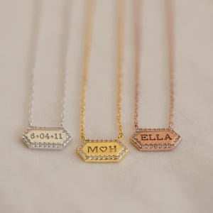 May include: A set of three ceramic mugs with a speckled, matte finish. The mugs are in shades of cream, light gray, and dark gray. Each mug has a simple, minimalist design and a rounded handle.