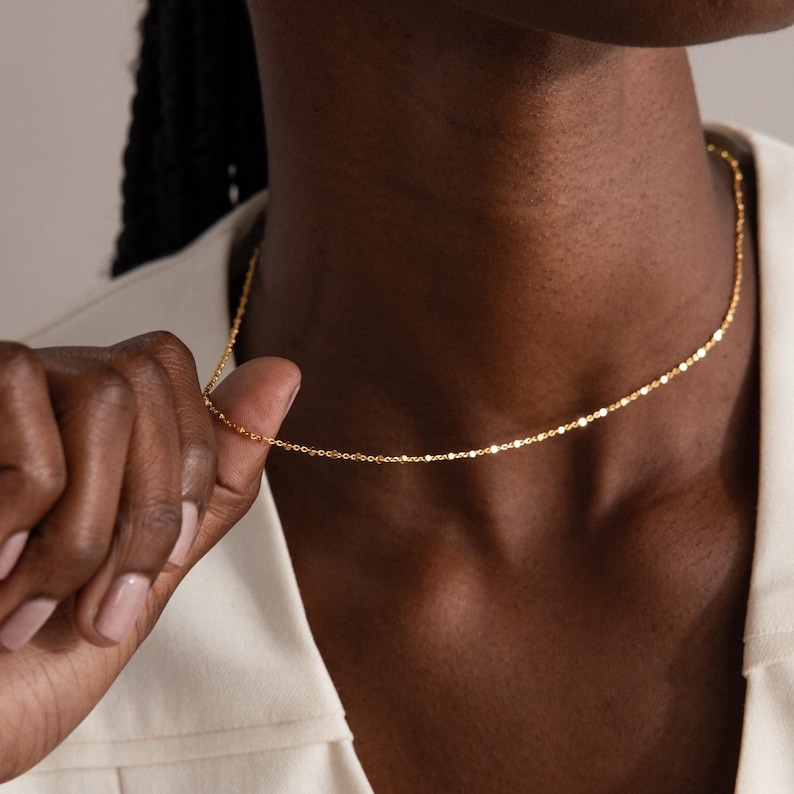 Model wearing the Dot Station Necklace in gold, featuring a dainty beaded chain design.