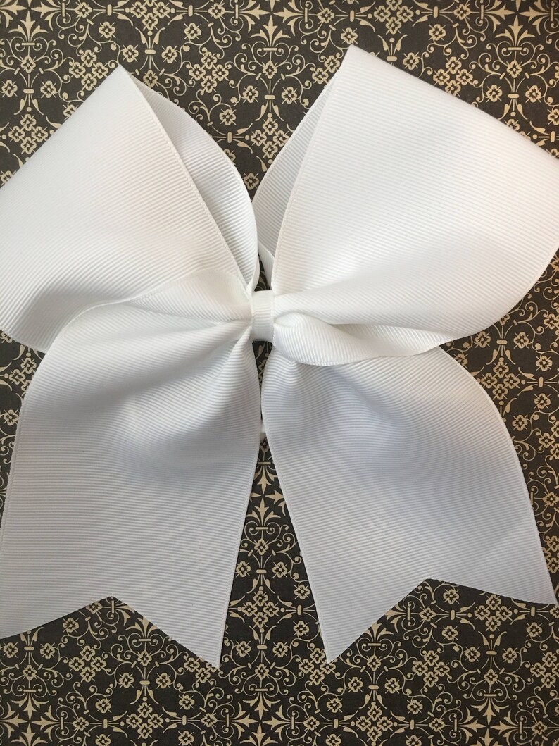 May include: A large white bow made of grosgrain ribbon. The bow is tied with a single loop in the center.