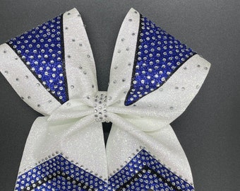 May include: White cheer bow with black and royal blue glitter and rhinestones. The bow has a chevron pattern.