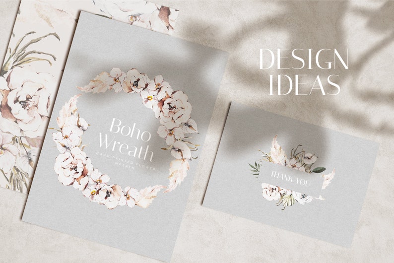 May include: A set of three cards with a watercolor floral design. The cards feature a wreath of white flowers and greenery, with the text "boho wreath" on one card and "thank you" on another. The cards are on a light gray background.
