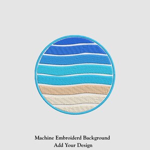 May include: Embroidered circular design featuring horizontal stripes in shades of blue, turquoise, and beige, resembling a stylized seascape. The design is outlined in a light blue border. Text at the bottom reads "Machine Embroidered Background Add Your Design."
