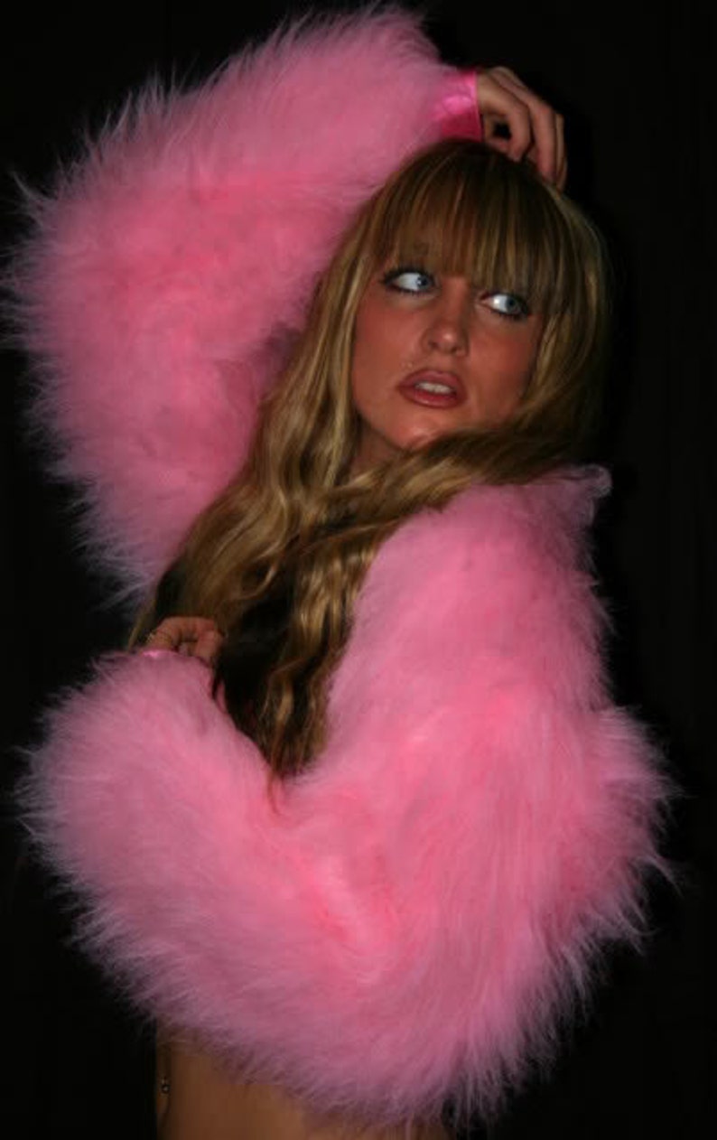 Puede incluir: Una chaqueta rosa de pelo con mangas largas. La chaqueta est&aacute; hecha de un material suave y mullido y tiene un corte casual y holgado.