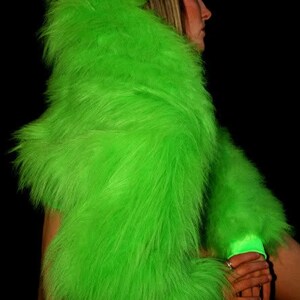 May include: A bright green faux fur shrug with long sleeves. The fur is very fluffy and soft.