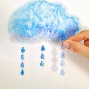 May include: A watercolour painting of a blue cloud with raindrops falling from it. The raindrops are also painted in watercolour and are a lighter shade of blue.