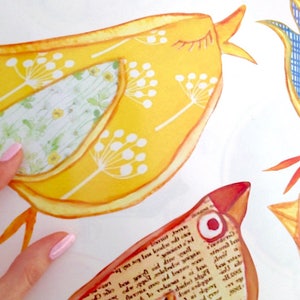 May include: A set of four colorful bird-shaped wall decals. The birds are made of paper and have a patchwork design. The birds are yellow, blue, red, and green.