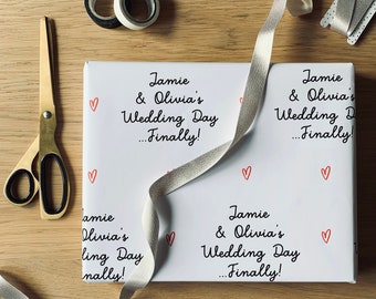 May include: White gift wrap with red hearts and the text "Jamie & Olivia's Wedding Day...Finally!" repeated four times.
