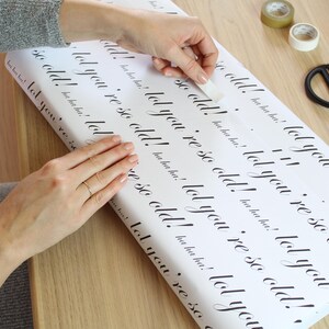 May include: White wrapping paper with the text "lol you're so old!" repeated in black cursive writing.