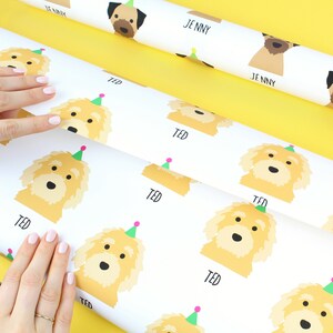 K&ouml;nnte beinhalten: Wei&szlig;es Geschenkpapier mit einem sich wiederholenden Muster eines gelben Hundes, der einen rosa-gr&uuml;nen Partyhut tr&auml;gt. Der Text "TED" ist unter jedem Hund gedruckt.